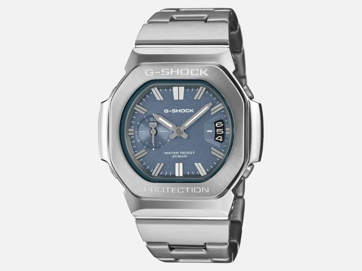 GMC-2500D blue dial, straight-on product shot. Caption: “0–60 subdial doing seconds duty, date at three, no digital window anywhere. That’s the real break from the CasiOak.”